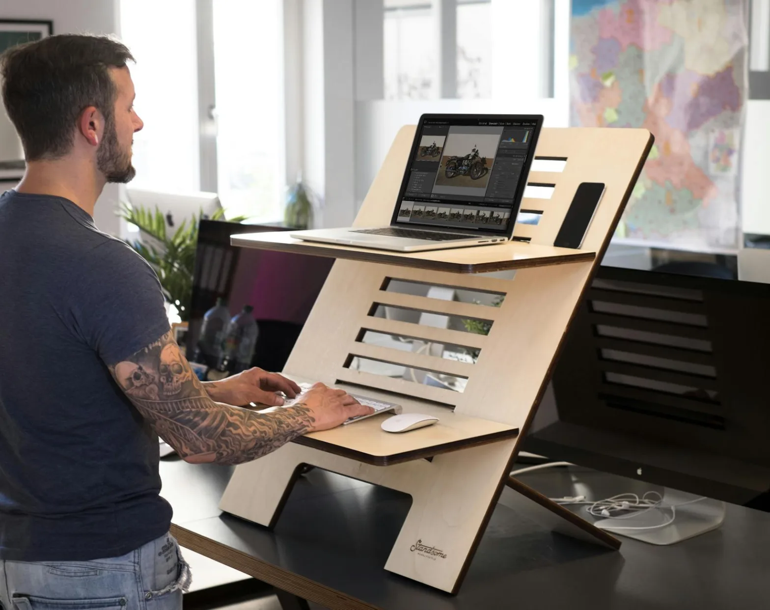a man in gray shirt working on his laptop inside the office