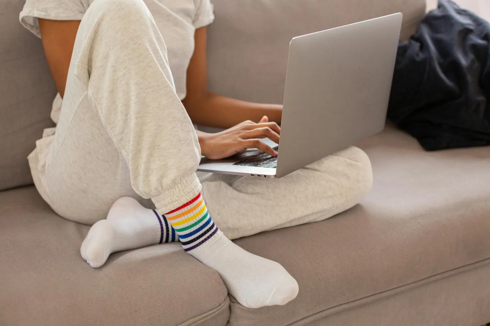 person in gray sweater using macbook
