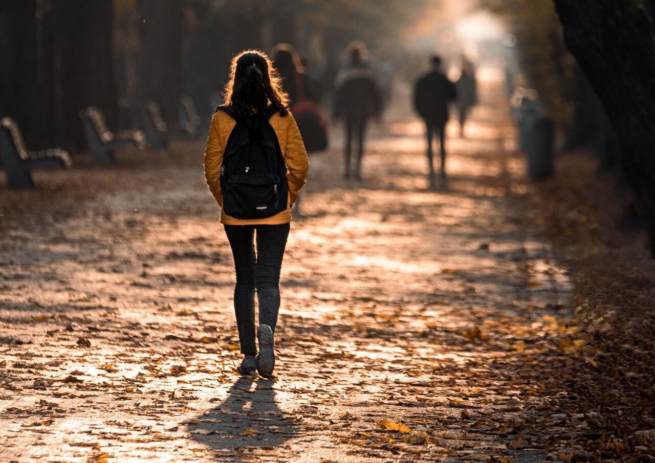 Kvinna går i parken höstpromenad